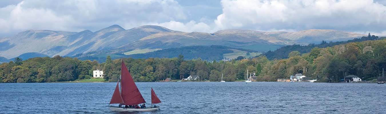 Lake District sailing boat with club house on the shore